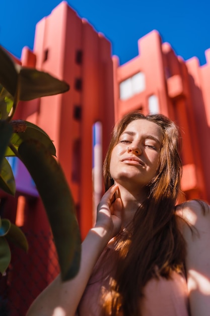 Jeune femme caucasienne profitant de l'été sur une maison orange de fond