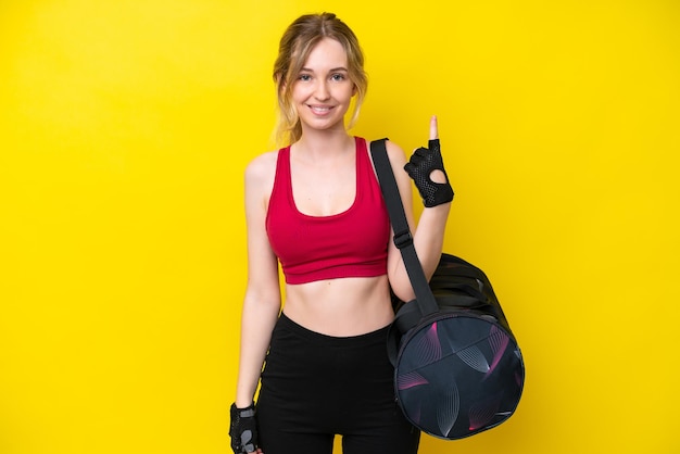 Jeune femme caucasienne sport avec sac de sport fond isolé pointant avec l'index une excellente idée