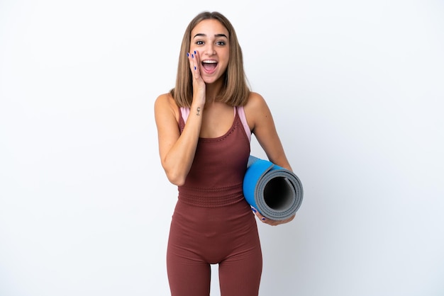 Jeune femme caucasienne sportive allant à des cours de yoga isolés sur fond blanc avec une expression faciale surprise et choquée