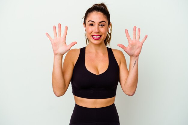 Jeune femme caucasienne sportive isolée sur blanc montrant le numéro dix avec les mains.