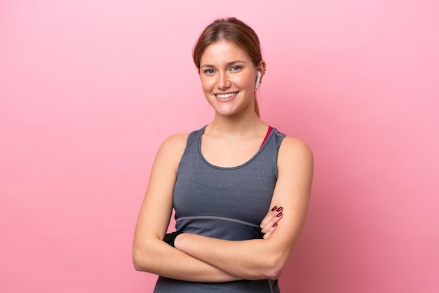 Jeune femme caucasienne sportive isolée sur fond rose en gardant les bras croisés en position frontale