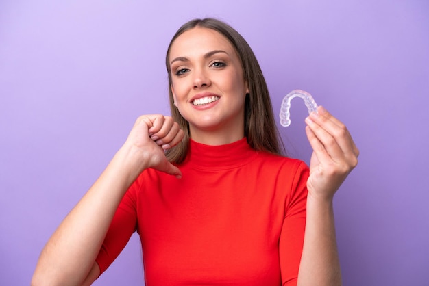 Jeune femme caucasienne tenant des accolades invisibles fière et satisfaite