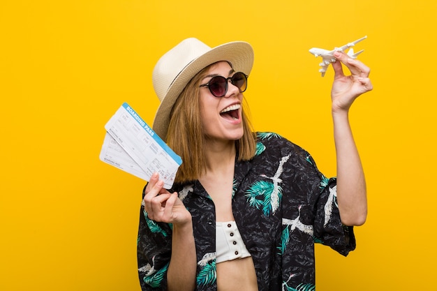 Jeune femme caucasienne tenant des billets d'avion très heureux.