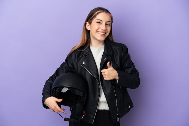 Jeune femme caucasienne tenant un casque de moto isolé