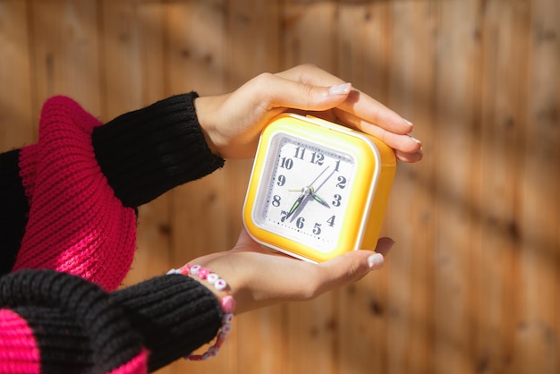 Une jeune femme caucasienne tenant une horloge