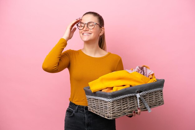 Jeune femme caucasienne tenant un panier à vêtements isolé sur fond rose a réalisé quelque chose et a l'intention de trouver la solution