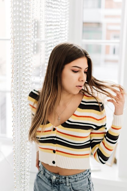 Jeune femme caucasienne touche la boucle de cheveux. concept de santé des cheveux