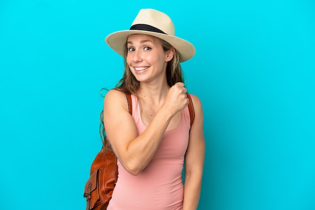 Jeune femme caucasienne en vacances d'été isolée sur fond bleu célébrant une victoire