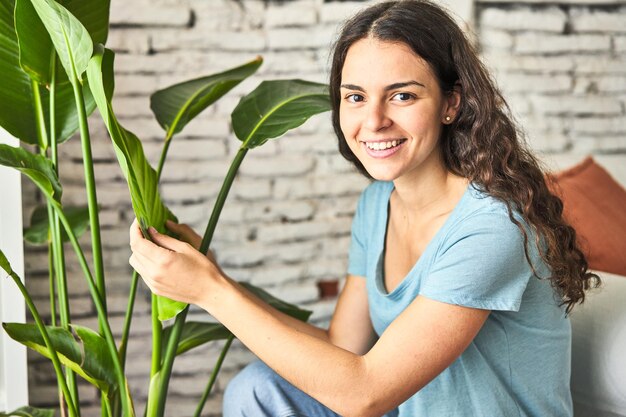 Une jeune femme caucasienne vérifiant attentivement les feuilles de son