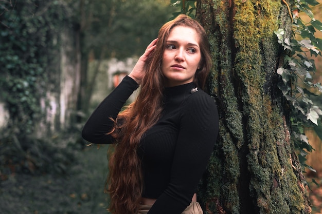 Jeune femme caucasienne avec des vêtements décontractés posant dans la forêt.