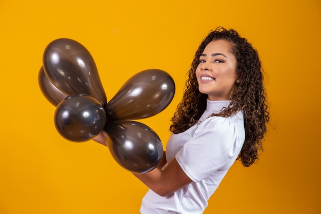 Jeune femme célébrant sa fête d'anniversaire avec un tas de montgolfières.