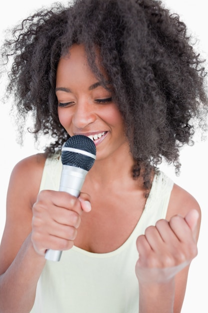 Jeune femme chantant karaoké avec un microphone