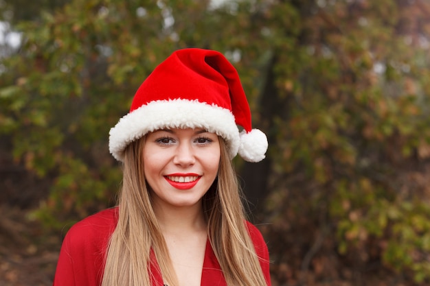 Jeune femme avec un chapeau de Noël dans la forêt