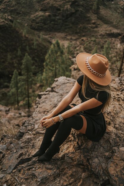 Jeune femme avec chapeau sur le terrain en regardant la caméra