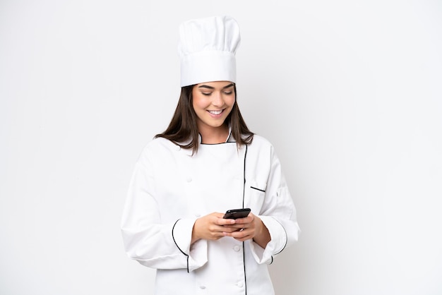 Jeune femme chef brésilienne isolée sur fond blanc envoyant un message avec le mobile