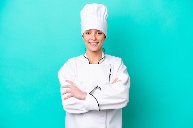 Jeune femme chef caucasienne isolée sur fond bleu tenant les bras croisés en position frontale