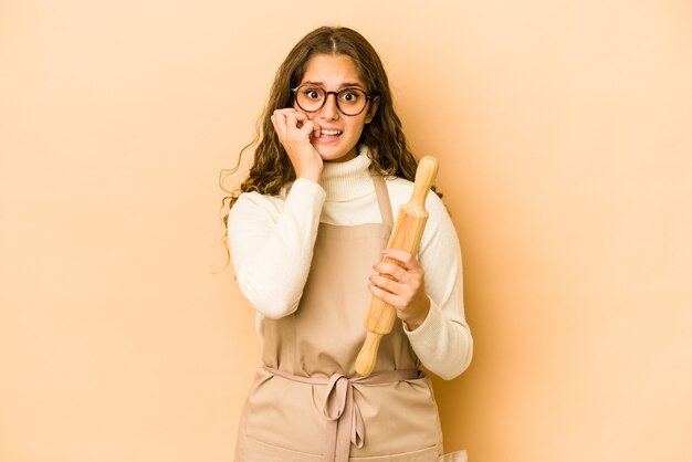 Jeune femme chef caucasienne isolée se rongeant les ongles, nerveuse et très anxieuse.