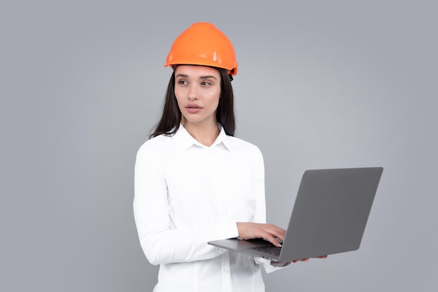 Jeune femme chef de chantier femme constructeur portrait isolé avec casque de protection et ordinateur portable