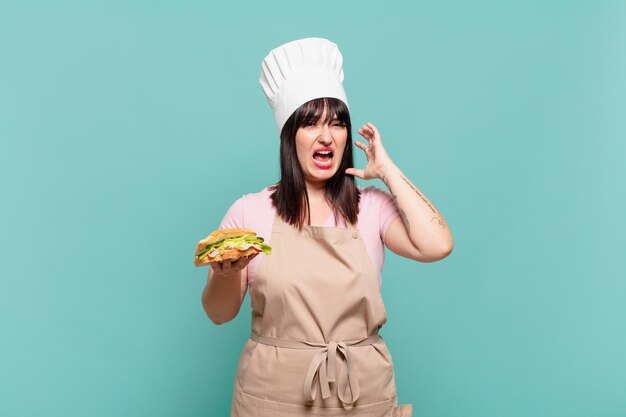 Jeune femme chef criant les mains en l'air, se sentant furieuse, frustrée, stressée et contrariée