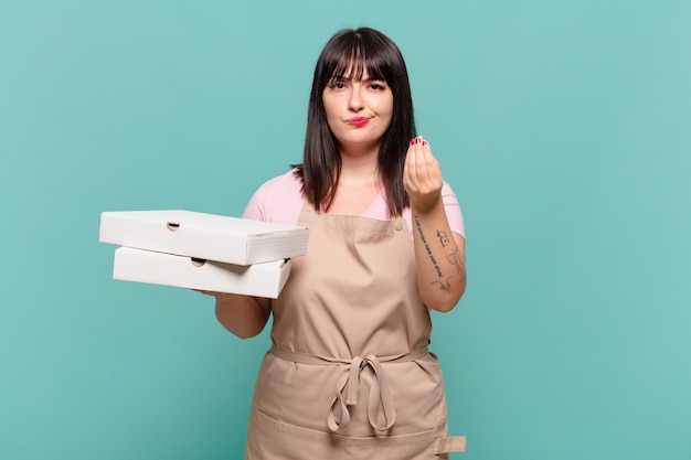 Jeune femme chef faisant un geste de capice ou d'argent, vous disant de payer vos dettes !