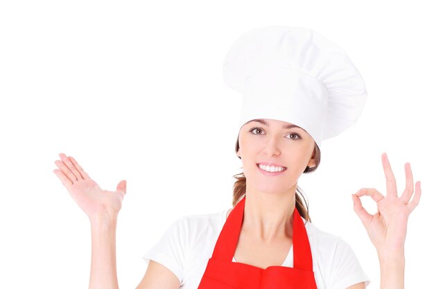 une jeune femme chef montrant quelque chose sur fond blanc