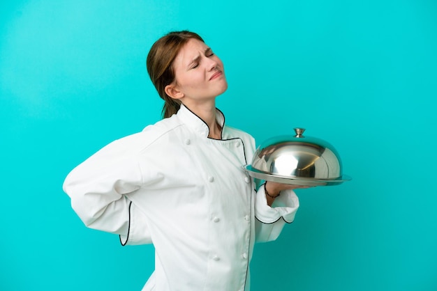 Jeune femme chef avec plateau isolé sur fond bleu souffrant de maux de dos pour avoir fait un effort