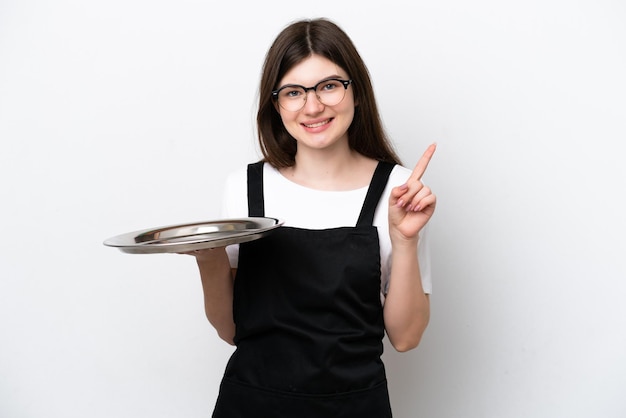 Jeune femme chef russe avec plateau isolé sur fond blanc montrant et levant un doigt en signe du meilleur