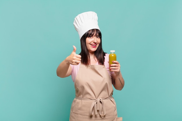 Jeune femme chef se sentant fière, insouciante, confiante et heureuse, souriant positivement avec le pouce levé