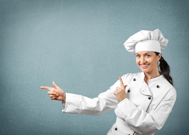 Jeune femme chef souriant et pointant