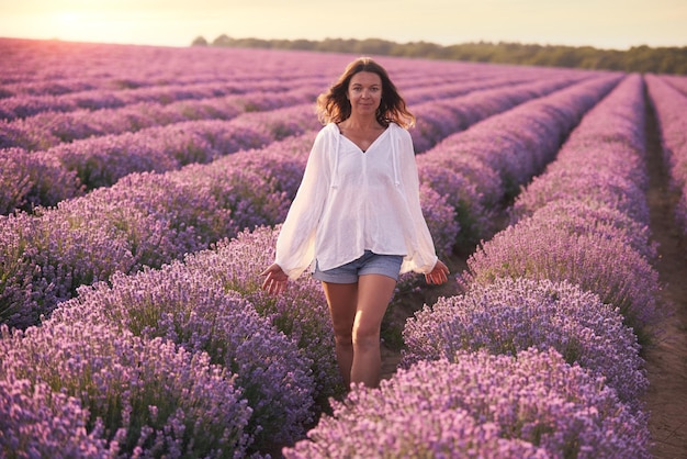 Jeune femme en chemise blanche dans un beau champ de lavande