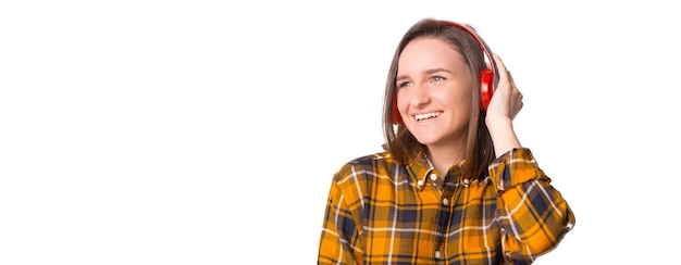 Jeune femme en chemise à carreaux appréciant la musique avec ses nouveaux écouteurs