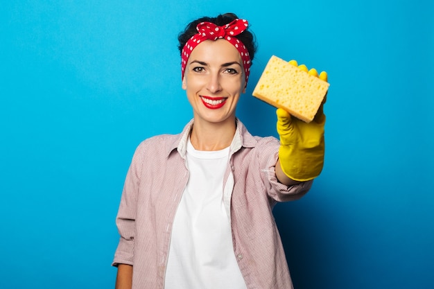 Jeune femme en chemise avec des gants de nettoyage