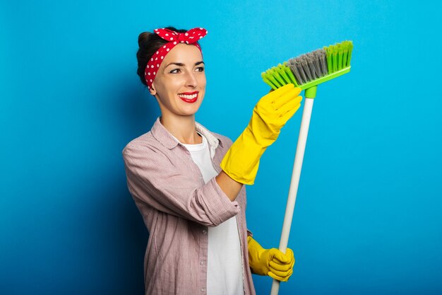 Jeune femme en chemise avec des gants de nettoyage