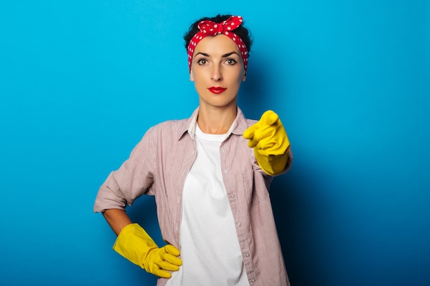 Jeune femme en chemise avec des gants de nettoyage