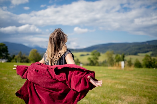 Jeune femme en chemise rouge s'amuser dans les montagnes