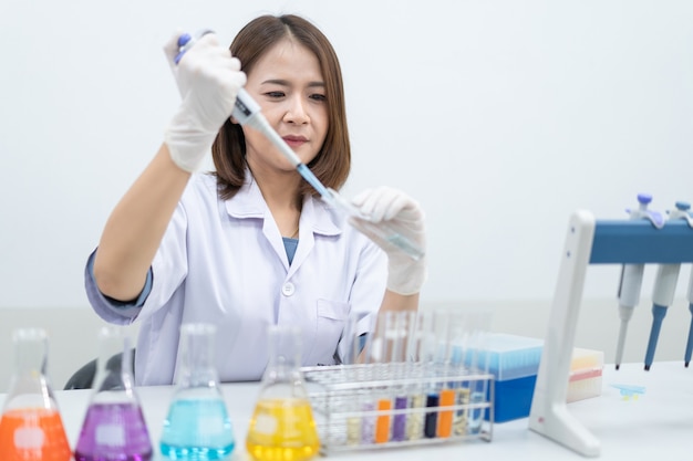 Une jeune femme chercheuse, médecin, scientifique ou assistante de laboratoire travaillant avec des tubes médicaux en plastique pour effectuer des recherches, examine des expériences scientifiques dans un laboratoire moderne. Éducation stock photo