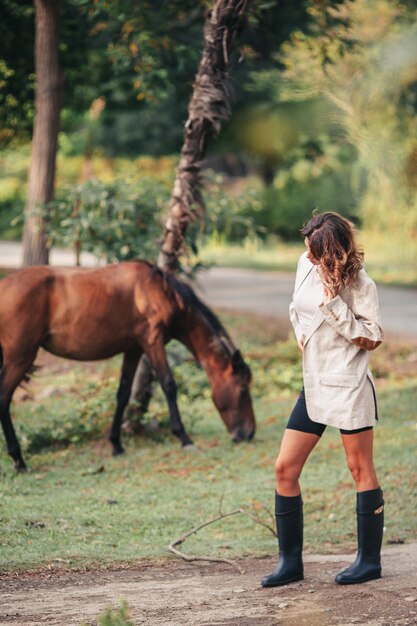Jeune femme avec cheval sauvage à l'extérieur