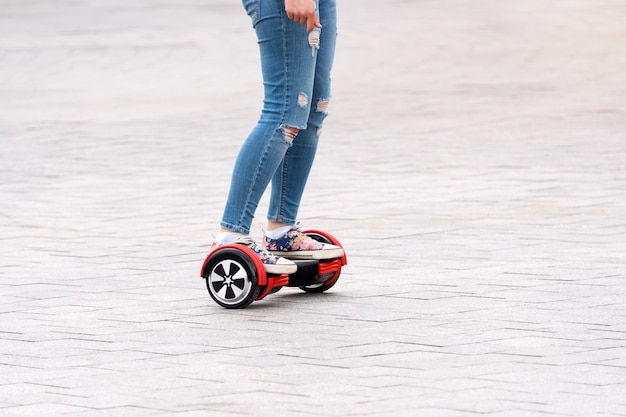 Jeune femme chevauchant un hoverboard sur la place de la ville