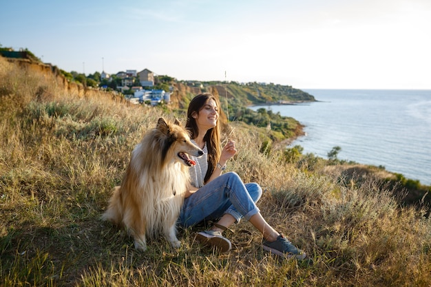 Une jeune femme et un chien âgé se promènent dans la campagne un soir d'été. Une dame et son fidèle ami d'enfance un chien colley