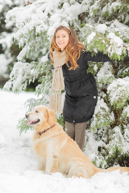 Jeune femme avec chien en hiver