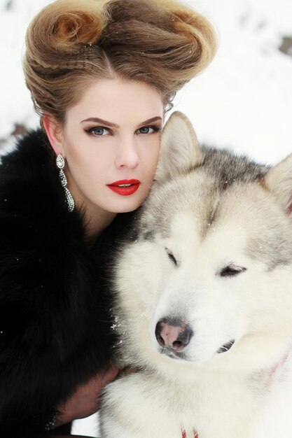 Photo une jeune femme avec un chien loup dans la neige