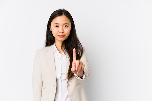 Jeune femme chinoise d'affaires isolé montrant le numéro un avec le doigt.