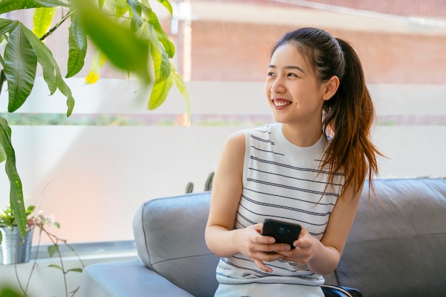 Jeune femme chinoise à l'aide de smartphone