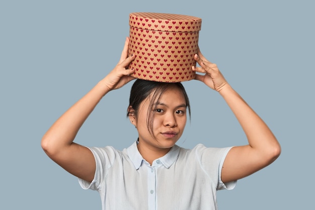 Jeune femme chinoise avec une boîte à cœur dans le studio