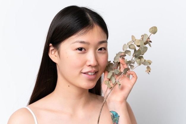 Jeune femme chinoise isolée sur fond blanc tenant une branche d'eucalyptus Close up portrait