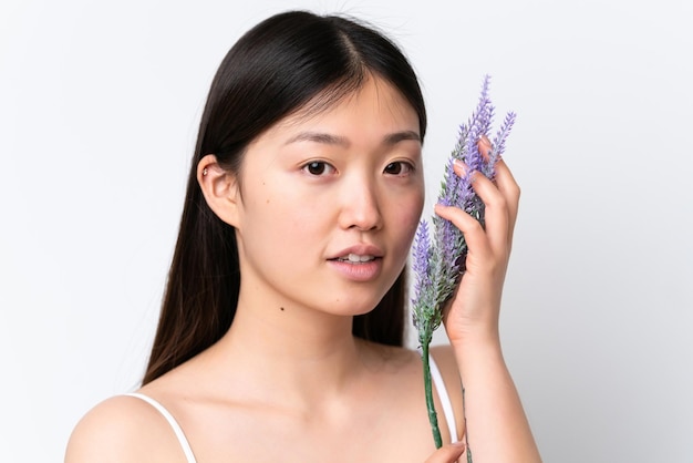 Jeune femme chinoise isolée sur fond blanc tenant un plant de lavande Close up portrait