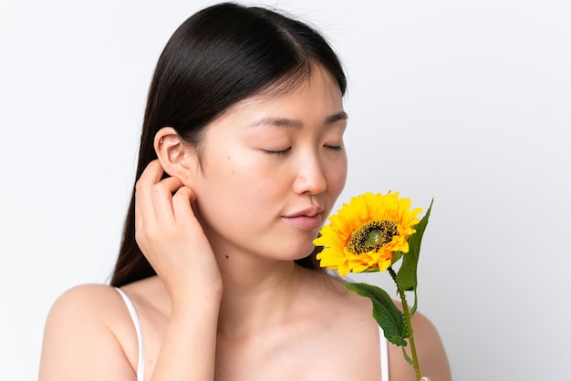 Jeune femme chinoise isolée sur fond blanc tenant un tournesol Close up portrait