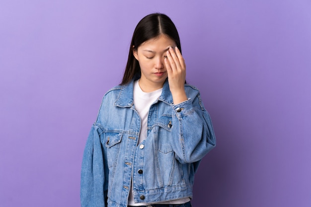 Jeune femme chinoise isolée avec des maux de tête