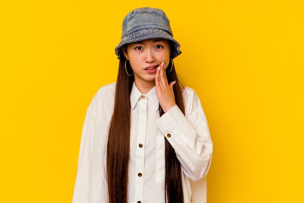 Jeune femme chinoise isolée sur un mur jaune ayant une forte douleur dentaire, une douleur molaire.