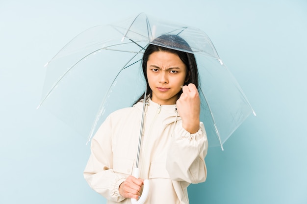 Jeune femme chinoise avec un parapluie en riant et en s'amusant.